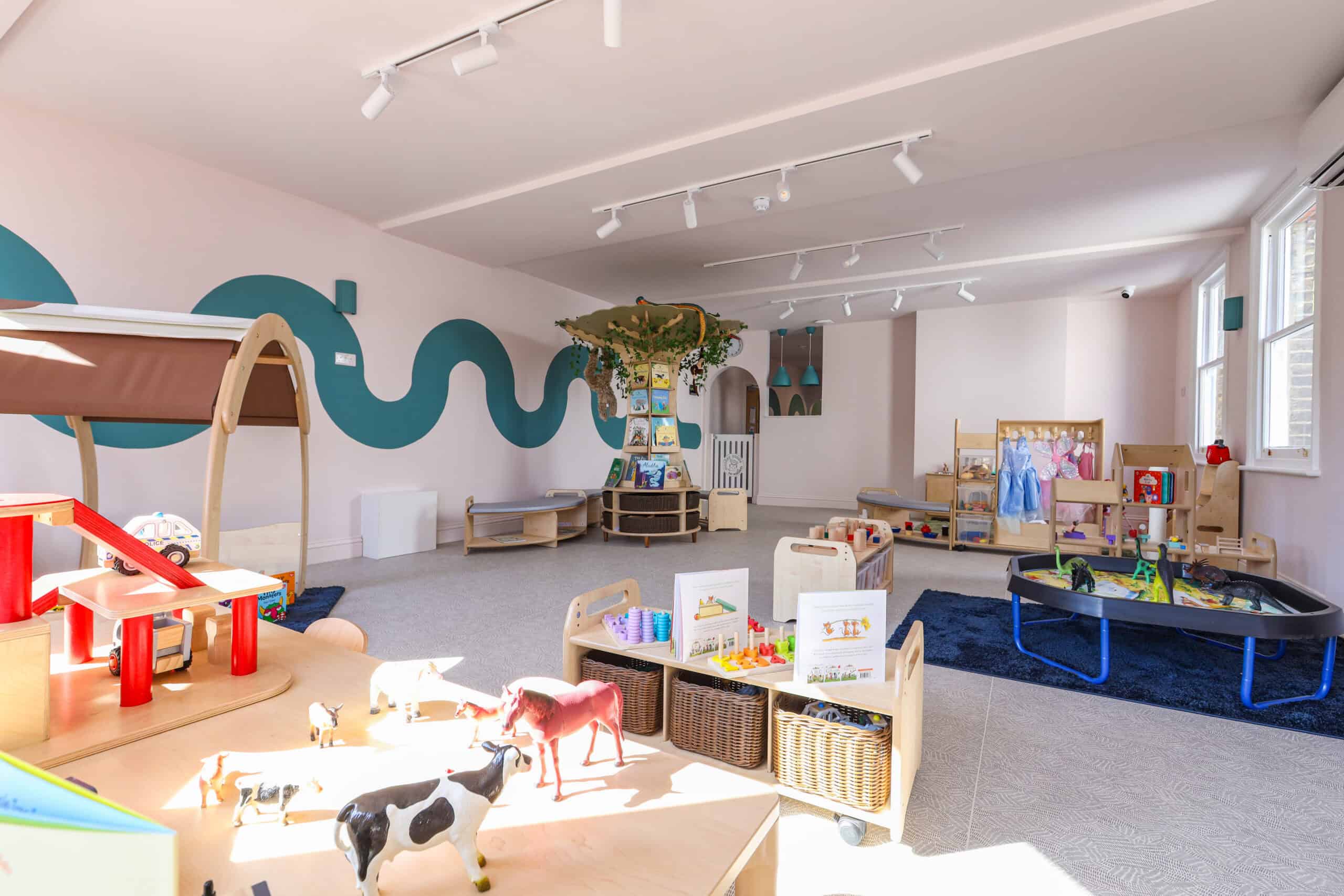 Bright and welcoming nursery room with toys, play areas, and natural light.
